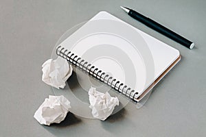 Blank notepad, pen and crumpled paper on office desk