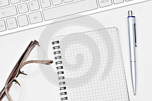 Blank notepad with pen and keyboard computer