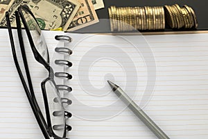 Blank notepad, pencil, glasses and dollar banknotes