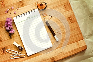 Blank notepad with pencil on wooden table