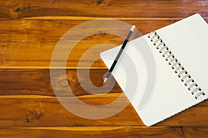 Blank notepad with pencil on wooden table