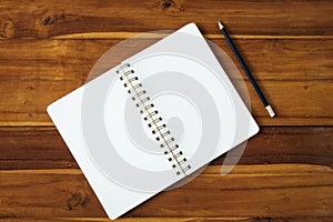 Blank notepad with pencil on wooden table