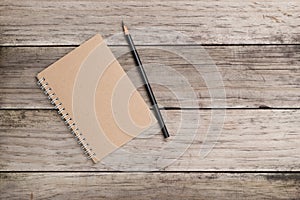 Blank notepad and pencil on the wooden table.