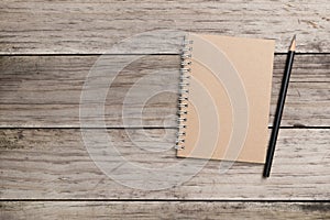 Blank notepad and pencil on the wooden table.