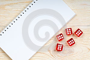 Blank notepad with red dices with six