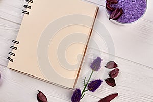 Blank notepad and spa treatment stuff on white wood.