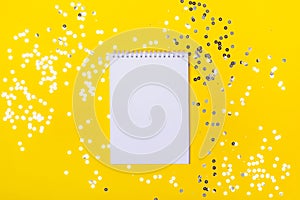 Blank notepad on yellow background with sparkles. Place for any list - plans, totals, successes photo
