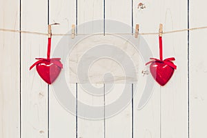 Blank old paper and red heart hanging on wood board background