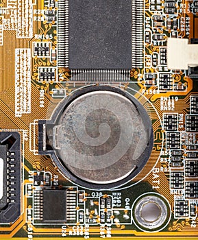 Blank old rusted aged CMOS battery on the motherboard macro, closeup, simple top view, from above. Replacing bios battery