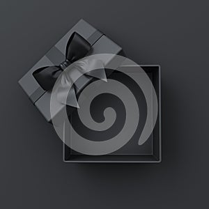 Blank open black present box or top view of black gift box with black ribbons and bow on dark background with shadow