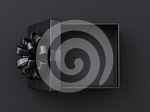 Blank open black present box or top view of opened black gift box with black ribbons and bow on dark background with