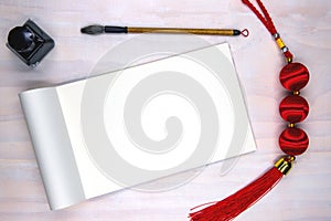 Blank open notebook page and calligraphy supplies. Oriental decoration flat lay on white wooden table