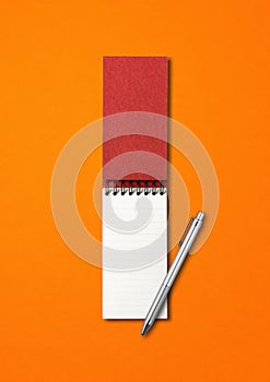 Blank open spiral notebook and pen isolated on orange