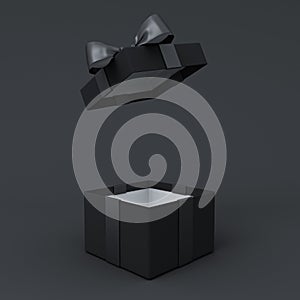 Blank opening black present box or black gift box with black ribbons and bow on dark background with shadow minimal