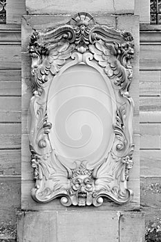 Blank ornate headstone on wall of building