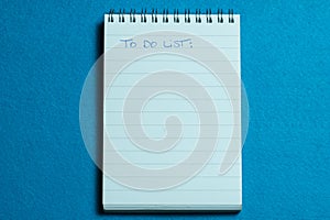 Blank page of notebook and to do list on light blue background