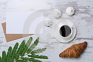 Blank page on rustic wooden background with croasant, coffee, marshmallows. Vintage mockup with text place