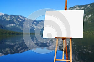 Blank painter artist canvas on easel with lake in background