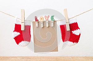 Blank paper with baby socks hanging on love clothesline