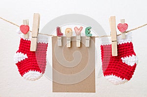 Blank paper with baby socks hanging on love clothesline