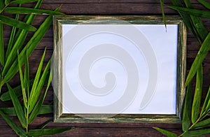 Blank paper and bamboo flat lay on wooden background. Natural rustic photo frame with blank place for text