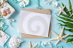 Blank paper on blue pastel background with shells and starfish, empty note for holidays on beach