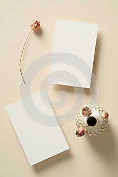Blank paper cards templates with dried flowers on beige background. Flat lay, top view, copy space