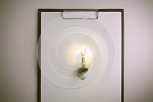 Blank paper with an illuminated light bulb idea concept