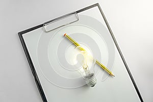 Blank paper with an light bulb and pencil waiting for idea concept with light