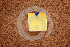 A blank paper note pinned on a cork board