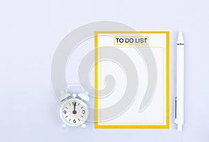 The Blank paper note To do list or wish and alarm clock with pen on gray color background