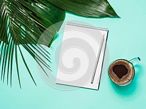 Blank paper notebook and tropical leaves