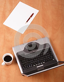 Blank paper, pen cup of coffee and laptop on the desk