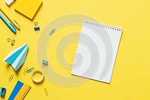 Blank paper school notebook mockup and stationery on yellow background. Back to school concept. Flat lay, top view, copy space