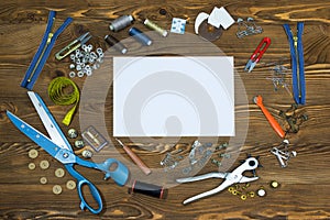 Blank paper and Sewing tools on wooden textured background, copy-space.