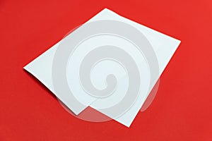 Blank paper sheet on bright red background.
