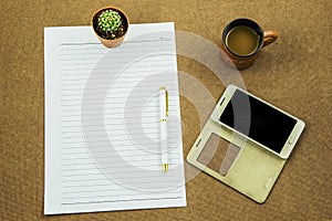 Blank paper with smart phone pen and coffee cup on wooden table, business concept