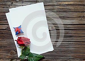 Blank papers on table with rose and gift