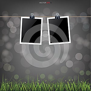 Blank photo frame in green grass field and light blurred bokeh background. Vector