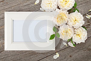 Blank photo frame and white roses