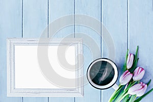 Blank Picture Frame with Coffee and Flowers over Blue Spring Background