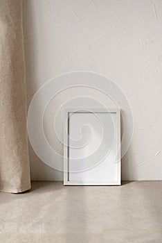 Blank picture frame with mockup copy space on beige stone tabletop, minimalist neutral aesthetic home interior, empty white wall