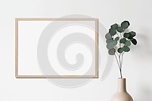 Blank picture frame mockup on white wall horizontal template. Artwork in minimal interior design.