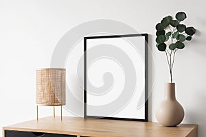 Blank picture frame mockup on white wall vertical template. Artwork in minimal interior design.