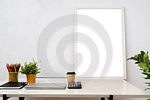 Blank picture frame on wooden table with books