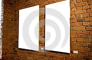 Blank picture frames on brick wall with glowing lamp, mock up