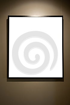 Blank picture frames on brown wall with glowing lamp, mock up