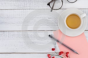 Blank pink card ,pen ,eyeglasses and a cup of tea