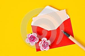 Blank pink paper card in red envelope letter and pen.