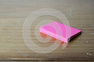 Blank pink sticky note block on desk.